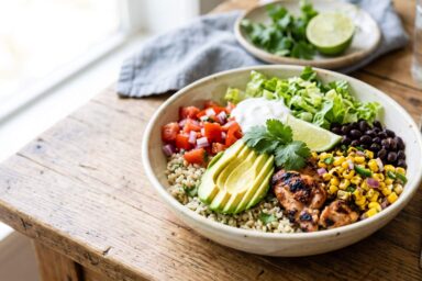 Healthy copycat Chipotle burrito bowl with chipotle chicken, cilantro lime brown rice, black beans, roasted corn salsa and avocado