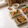 Macro balanced meal prep with high-protein chicken, salmon, vegetables, rice, and sweet potatoes