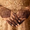 Beautiful floral and Arabic-style mehndi designs on a woman's hands with intricate natural henna patterns.