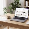 Woman-free home office workspace showing Canva templates on a laptop, digital products, and business mockups for making $100 a day.